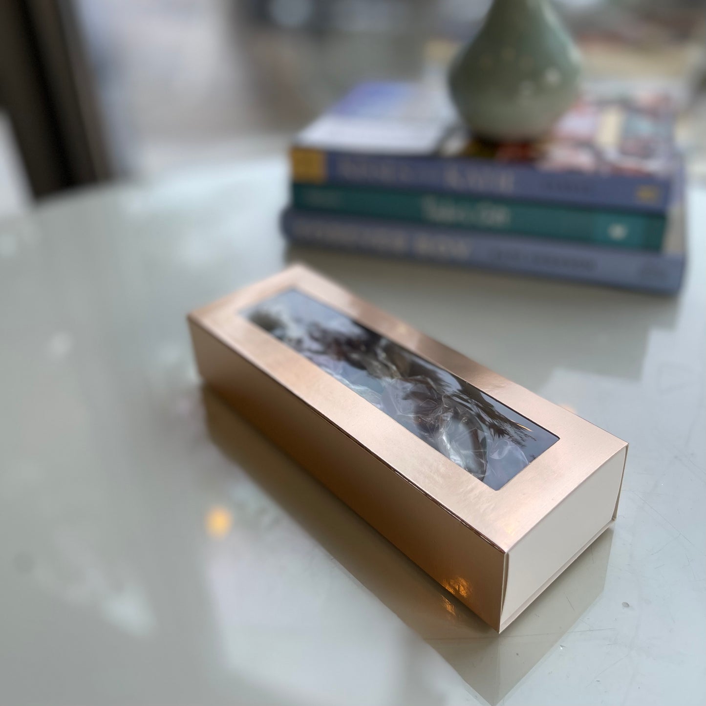 Kicking Caramels by Cove Tea Co with books and a dried flower arrangement.